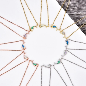 Detailed view of dolphin pendants with colorful opal inlay in gold and silver finishes