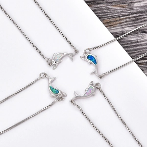 Macro detail of dolphin necklaces with colorful opal inlay on a box chain for women