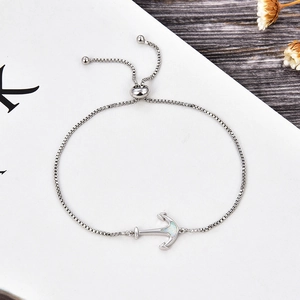 Detail of adjustable anchor bracelet with opal inlay and box chain on white background