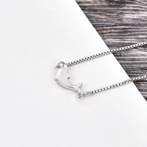 Detailed view of dolphin pendant with polished silver finish and cubic zirconia inlay