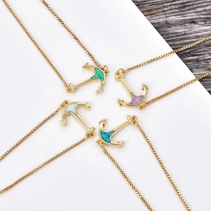 Detail view of four gold anchor pendants with colorful opal inlays on box chains