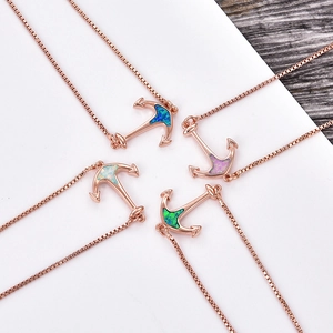 Close-up of four anchor necklaces with colorful synthetic opal in rose gold finish