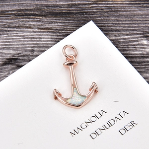 Detailed view of rose gold anchor pendant with iridescent white opal and zircon stone
