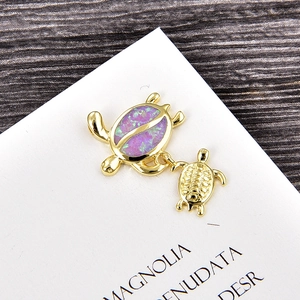 Macro shot of gold-plated turtle pendant featuring vibrant purple opal inlay on turtle shell