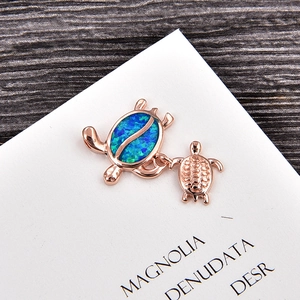 Detail of rose gold sea turtle pendant with vibrant blue-green opal inlay and turtle shell texture
