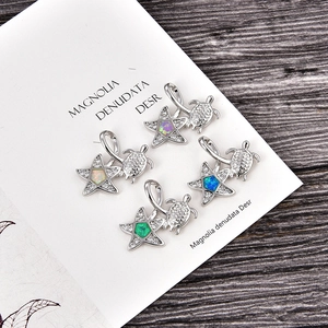 Detailed macro view of turtle pendants with opal hearts and sparkling zircon accents