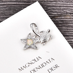 Detailed view of silver turtle and star pendant with opal inlay and zircon accents