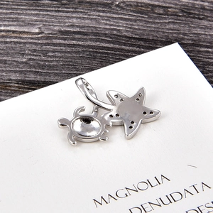 Detailed view of silver sea turtle and starfish pendant with opal and cubic zirconia