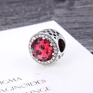Macro detail of S925 sterling silver charm with red crystal and cubic zirconia stones