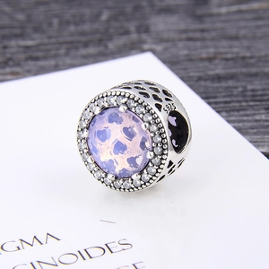 Detailed macro view of S925 silver charm bead with lavender stone and heart-shaped cutouts