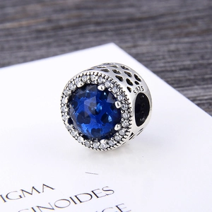 Macro view of S925 silver charm with blue stone and heart hollow design detail