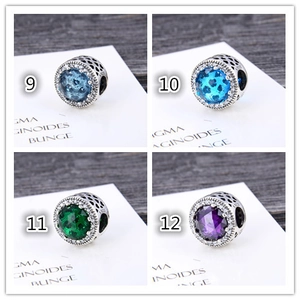 Macro detail of S925 silver charms with colorful zircons and heart hollow pattern