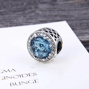Macro detail of S925 sterling silver charm with blue zircon and hollow heart patterns
