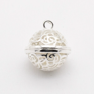 Detailed macro view of silver hollow bell pendant with intricate floral DIY craft pattern