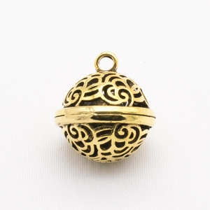 Macro shot of golden filigree hollow ball pendant for handmade jewelry making