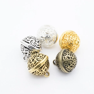 Detailed view of five hollow filigree metal ball pendants for DIY jewelry making