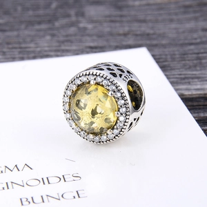 Close-up of S925 silver charm with yellow crystal and hollow heart details