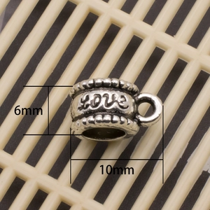 Detail der silbernen Herzperle mit LOVE-Gravur und Maßangaben von 6 mm mal 10 mm