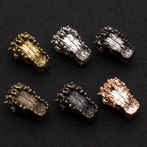 Detailed view of six vintage alloy crocodile head charms in varied metallic finishes