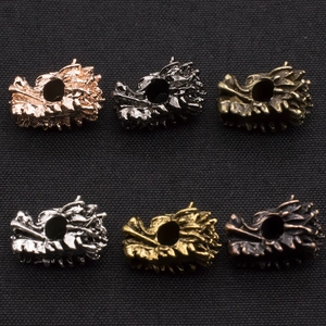 Macro detail of alloy dragon head beads in six metallic finishes for DIY jewelry making