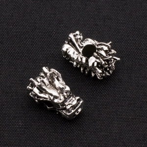 Macro shot of vintage silver dragon head alloy beads with intricate scale details for DIY jewelry