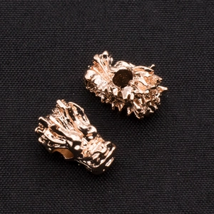 Detailed view of two rose gold dragon head beads for DIY jewelry and bracelets