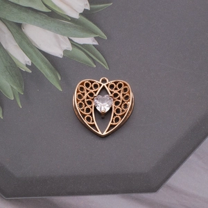 Detailed view of golden heart birdnest pendant with center crystal and wire mesh