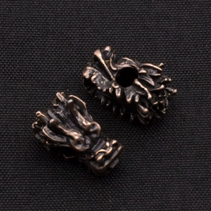 Macro detail of retro bronze dragon head beads with intricate carving for DIY jewelry