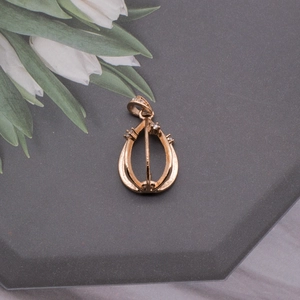 Detail of rose gold pear-shaped hollow pendant base with micro zircons on gray stand
