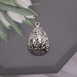 Macro detail of teardrop bird nest metal pendant for DIY jewelry making