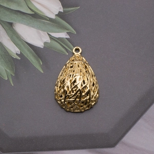 Macro shot of gold bird nest teardrop pendant with intricate hollow weave details