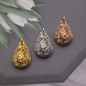 Detailed view of hollow teardrop woven pendants in gold, silver, and rose gold finishes