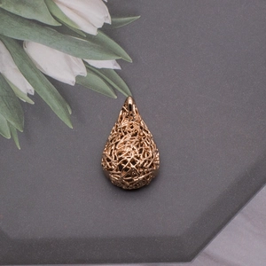 Detailed macro view of rose gold bird nest teardrop pendant with intricate woven design