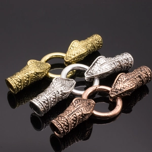 Macro detail of dragon head jewelry clasps in gold, silver, and bronze finishes