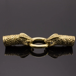 Macro shot of vintage dragon head jewelry connectors with scale texture in antique gold