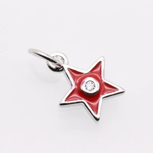 Macro shot of red star pendant with central zircon and polished silver metal edges