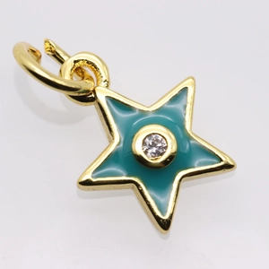 Macro detail of star-shaped gold-plated pendant with teal enamel and central zircon stone