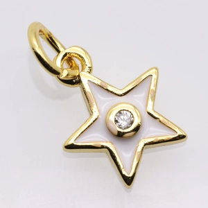 Macro shot of gold star pendant with white enamel inlay and central sparkling stone