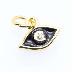 Macro detail of golden evil eye charm with black enamel and sparkling zircon inlay