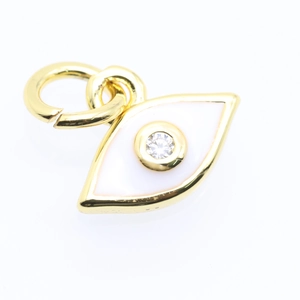Detail of a gold evil eye charm with white enamel and sparkling zircon stone