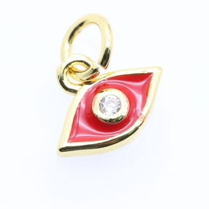 Macro shot of gold-plated evil eye pendant with red enamel and central clear zircon stone