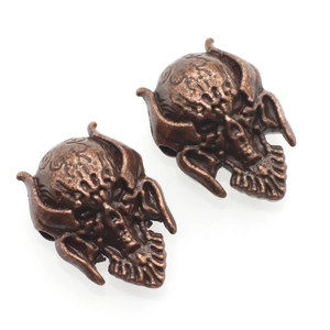 Detailed macro view of vintage bronze skull beads with dark distressed metal texture