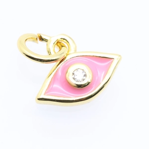 Macro detail of a gold-plated evil eye pendant with pink enamel and a crystal zircon