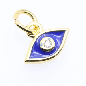 Macro detail of gold plated evil eye pendant with blue enamel and clear zircon stone