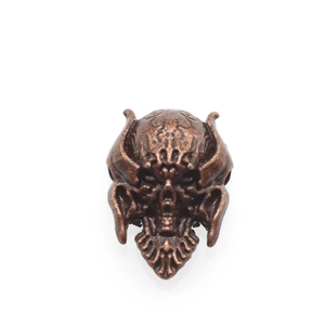 Macro shot of antique bronze skull bead with detailed punk relief for paracord jewelry