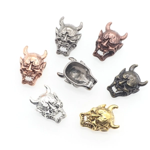 Macro shot of detailed Hannya mask charms in seven metallic finishes for DIY jewelry making