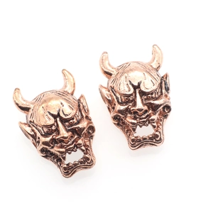 Macro shot of vintage Hannya mask beads in retro copper for jewelry making and DIY crafts