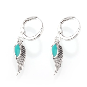 Detailed close-up of silver-plated angel wing earrings with turquoise enamel inlay