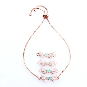 Detail of rose gold angel wing heart bracelet featuring opal and micro-pave zircons