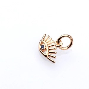 Vue macro d'un pendentif œil maléfique en or rose avec pierre bleue pour bijoux DIY